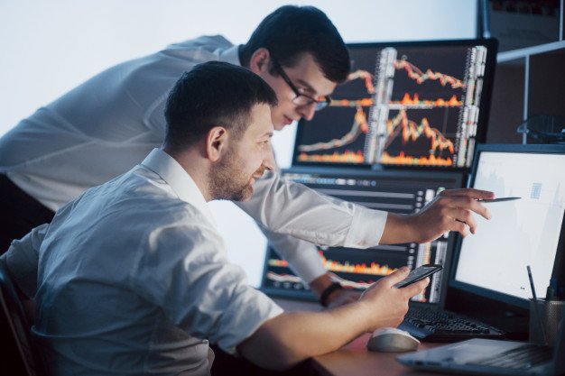 team-stockbrokers-are-having-conversation-dark-office-with-display-screens-analyzing-data-graphs-reports-investment-purposes-creative-teamwork-traders_146671-1038